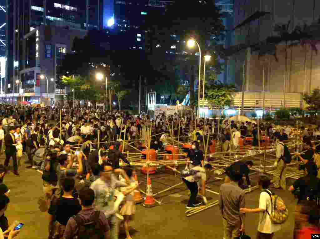数以百计占中支持者在金钟道从中银大厦至警察总部长达150的路段上加固多处路障 (美国之音海彦 拍摄)