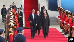 Menlu AS John Kerry (tengah kiri) melewati pesukan kehormatan bersama Wakil Menlu Korea Selatan Lee Kyung-soo (tengah kanan) setibanya di bandara militer di Seongnam, Seoul, Korea Utara (13/2).