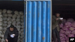 中国10月通胀率创25个月新高。在北京的一个蔬菜批发市场，蒜农一边吃午饭，一边等买主。