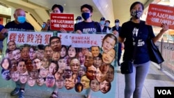 香港社民连主席陈宝莹(右起)与外务副主席周嘉发、成员余炜彬及前东区区议员曾健成，在十一中国国庆日游行，要求全中国实行普选、释放所有政治犯 (美国之音/汤惠芸)