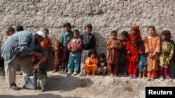 Anak-anak antri untuk menerima vaksinasi dalam kampanye anti-polio di pinggiran wilayah Jalalabad, Afghanistan (11/2).