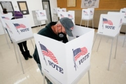 FILE - Chris Helps of Earlham, Iowa, fills out his ballot during early voting in Adel, Iowa, Oct. 20, 2020.