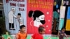 Anak-anak bermain di dekat mural di perkampungan untuk warga berpenghasilan rendah di Jakarta, 4 Agustus 2020. (AP Photo/Dita Alangkara)