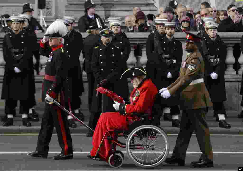 Sargent Johnson Beharry VC, wheels a Chelsea Pensioner past the Cenotaph as he gets ready to hand over his wreath during the Remembrance Sunday service at the Cenotaph in London.