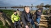 Britain's Prime Minister Boris Johnson climbs over a fence during a visit to see the effects of recent flooding, in Stainforth, England, Nov. 13, 2019. 
