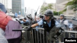 Waandamanaji wakikabiliana na polisi wa kuzuia ghasia wakati wa maandamano ya kupinga pendekezo la sheria ya kuwarudisha raia kujibu mashtaka nchini kwao karibu na bunge la Hong Kong, China Juni 12, 2019. REUTERS/Thomas Peter