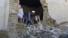 A man and his son clear the rubbles from their house after it was damaged by an earthquake in Behsud district of Nangarhar Province, Afghanistan, Oct. 27, 2015. 