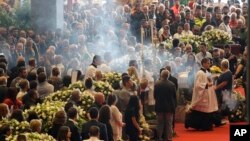 Incense is spread during a funeral service for some of the victims of a collapsed highway bridge, in Genoa's exhibition center Fiera di Genova, Italy, Saturday, Aug. 18, 2018.