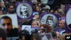 Para pengunjuk rasa membawa poster-poster orang Armenia yang menjadi korban pembunuhan massal pada masa Kekaisaran Ottoman 1915, dalam doa bersama di Istanbul, Turki, 24 April 2015. (Foto: AP)