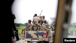 FILE - A Nigerian army convoy vehicle drives ahead with an anti-aircraft gun on its way to Bama, Borno State, Nigeria, Aug. 31, 2016.
