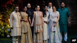 موکیش امبانی، ثروتمندترین مرد هند (چپ) با پسرش آننت امبانی (سوم از طرف چپ) و سایر اعضای خانوادهٔ امبانی.