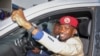 FILE - Ugandan presidential hopeful and political activist Bobi Wine, whose real name is Kyagulanyi Ssentamu, raises his fist in the air to gathered supporters as he leaves after meeting with the Electoral Commission, in Kampala, Uganda, Jan. 9, 2020.