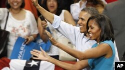 奥巴马总统和夫人5月5日在维吉尼亚州立邦联大学的集会上向人群挥手致意