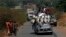 A vehicle filled with people and heavy load, precedes a convoy of over 100 trucks arriving in the Central African Republic capital Bangui from Cameroon, Monday Jan. 27, 2014. The trucks were loaded with military logistic for French forces and Humanitarian