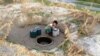 A village boy gathering water from dry sandy stream near Welaung Dam 