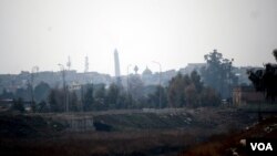 Iraqi soldiers say the tower in the distance is IS's main mosque in western Mosul and sniper fire regularly lands across the river aimed at them on Feb. 12, 2017 in Mosul, Iraq. (H.Murdock/VOA)