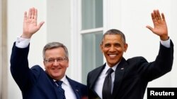 Presiden AS Barack Obama dan Presiden Polandia Bronislaw Komorowski (kiri) melambaikan tangannya di Istana Belveder, Warsawa (3/6). 