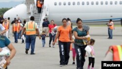 Dalam foto tertanggal 14/7/2014 ini para imigran dari Honduras tiba kembali di Bandara San Pedro Sula, Honduras, setelah dideportasi dari Amerika. 
