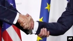 美国总统特朗普和法国总统马克龙在七国集团峰会的新闻发布会上握手（2019年8月26日）。