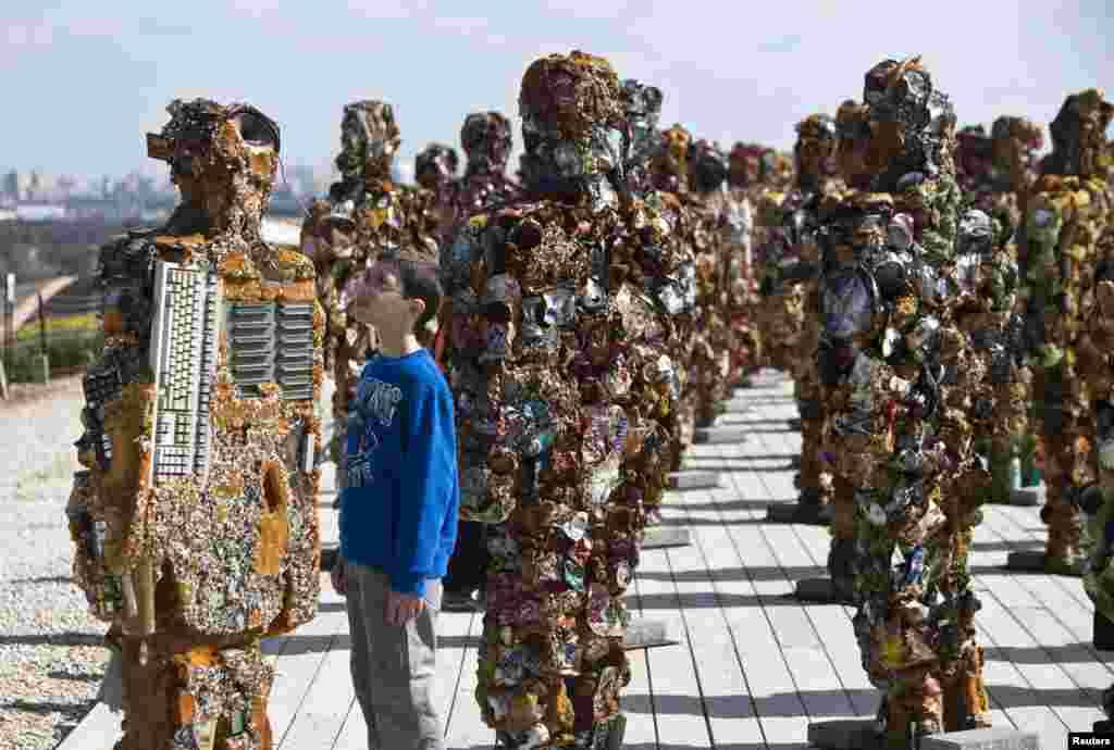 Seorang anak laki-laki Israel mengamati sebuah patung karya seniman Jerman,&nbsp;HA Schult, di taman Ariel Sharon dekat Tel Aviv, Israel.