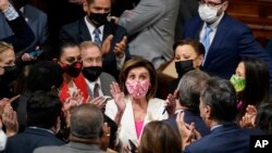 Speaker of the House Nancy Pelosi, D-Calif., celebrates the House passage of President Joe Biden's expansive social and environment bill with other Democrats in the House Chamber, at the Capitol in Washington on Nov. 19, 2021.