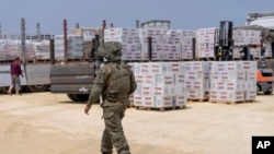 یک سرباز اسرائیلی در محل بازرسی خودروهای حامل کمک های بشردوستانه به نوار غزه، در گذرگاه ارز یا بیت حانون - آرشیو