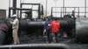 Sudanese workers inspect burnt out oil pipes at the oil-rich border town of Heglig, Sudan, April 24, 2012 (file photo). 
