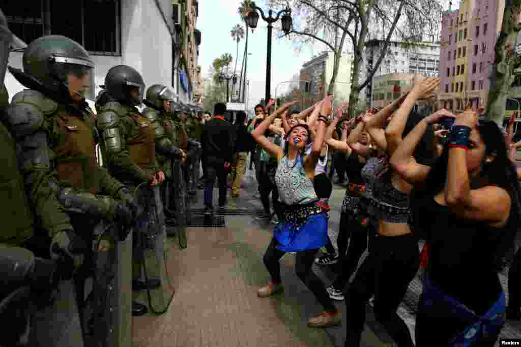 បាតុករ​កំពុង​រាំ​នៅ​ខាងមុខប៉ូលិស​កូបកម្ម​អំឡុង​ការហែក្បួន​មួយ​ធ្វើឡើង​ដោយ​និស្សិត​ដែល​ស្នើ​សុំ​ឲ្យ​មាន​ការផ្លាស់ប្តូរ​ប្រព័ន្ធអប់រំ​នៅ​ក្នុង ទីក្រុង​ Santiago ប្រទេស​ឈីលី​កាលពី​ថ្ងៃទី​០៥ កញ្ញា ២០១៧។ &nbsp;