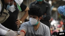 民众在伊斯兰堡街头的一个新冠病毒检测站接受检测（六月九号）。