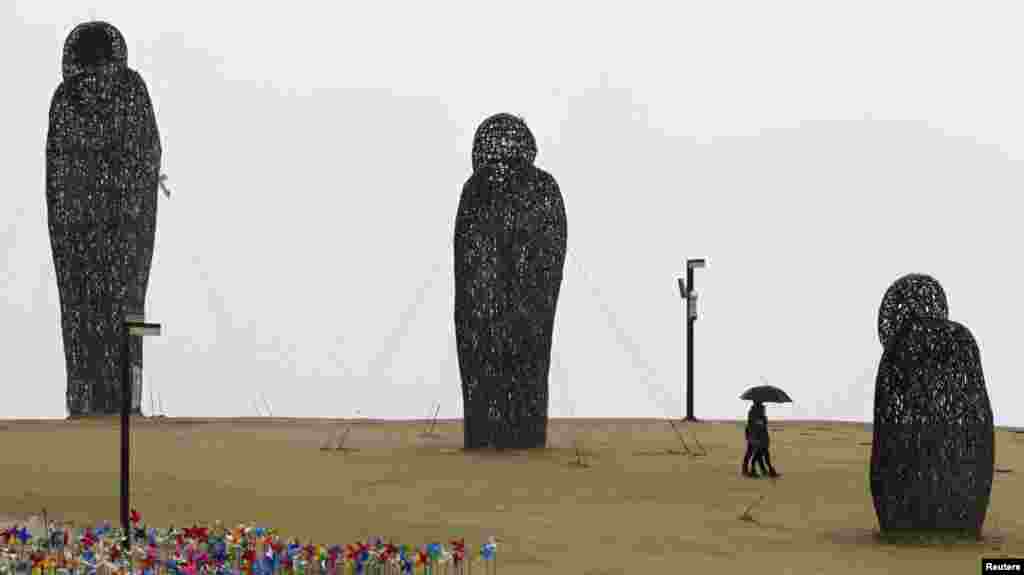 Sepasang laki-laki dan perempuan berjalan di &quot;Bukit Angin&quot; di Taman Perdamaian dekat zaona demilitarisasi yang memisahkan kedua Korea di Paju, sebelah utara Seoul, Korea Selatan.