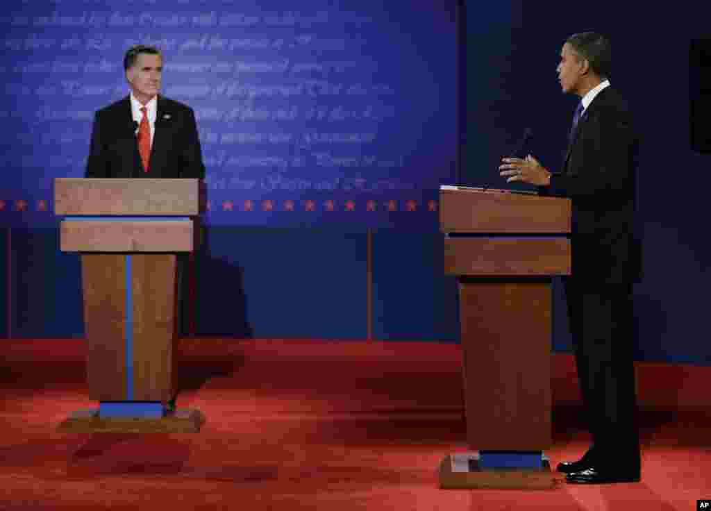 Presiden Barack Obama tersenyum ke arah moderator debat, Jim Lehrer, pada debat pertama capres AS 2012 di University of Denver (3/10).
