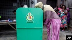 FILE - A woman casts her vote during a local government election in Lagos, Nigeria, July 22, 2017. 