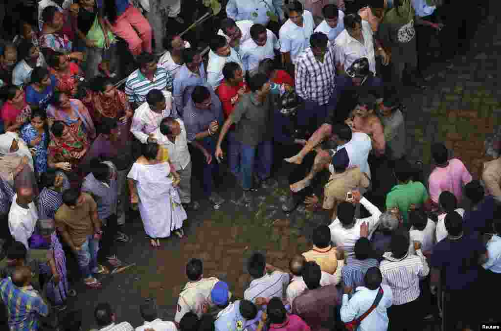 Para petugas penyelamatan membawa seorang pria yang terjebak di reruntuhan gedung ambruk (27/9).  