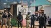 FILE - Security forces surround the entrance to the Electoral Commission as Ugandan presidential hopeful and political activist Bobi Wine, whose real name is Kyagulanyi Ssentamu, meets with them in Kampala, Uganda, Jan. 9, 2020. 