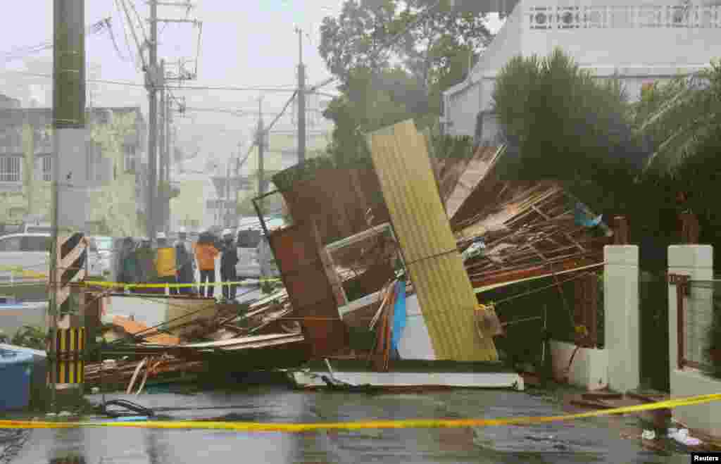 Sebuah rumah kayu ambruk akibat angin kencang yang disebabkan oleh Topan Neoguri di Naha, di pulau selatan Jepang, Okinawa, di foto yang diambil oleh Kyodo, 8 Juli 2014.