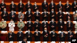 Delegates applaud as Chinese President Xi Jinping arrives for the opening session of China's National People's Congress (NPC) at the Great Hall of the People in Beijing, Friday, May 22, 2020. (AP Photo/Ng Han Guan, Pool)