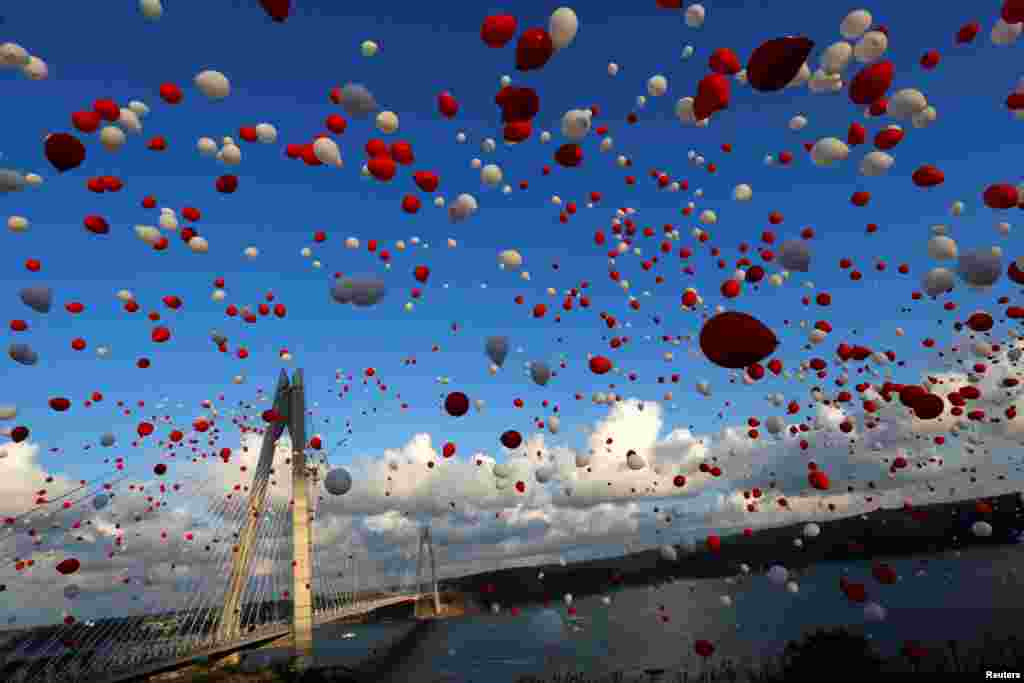 Balon-balon berwarna merah dan putih dilepaskan selama upacara pembukaan jembatan Yavuz Sultan Selim yang baru dibangun, jembatan ketiga yang membentang di atas Selat Bosphorus yang menghubungkan sisi kota Istanbul yang berada di benua Eropa dan di benua Asia.&nbsp; Istanbul, Turki.