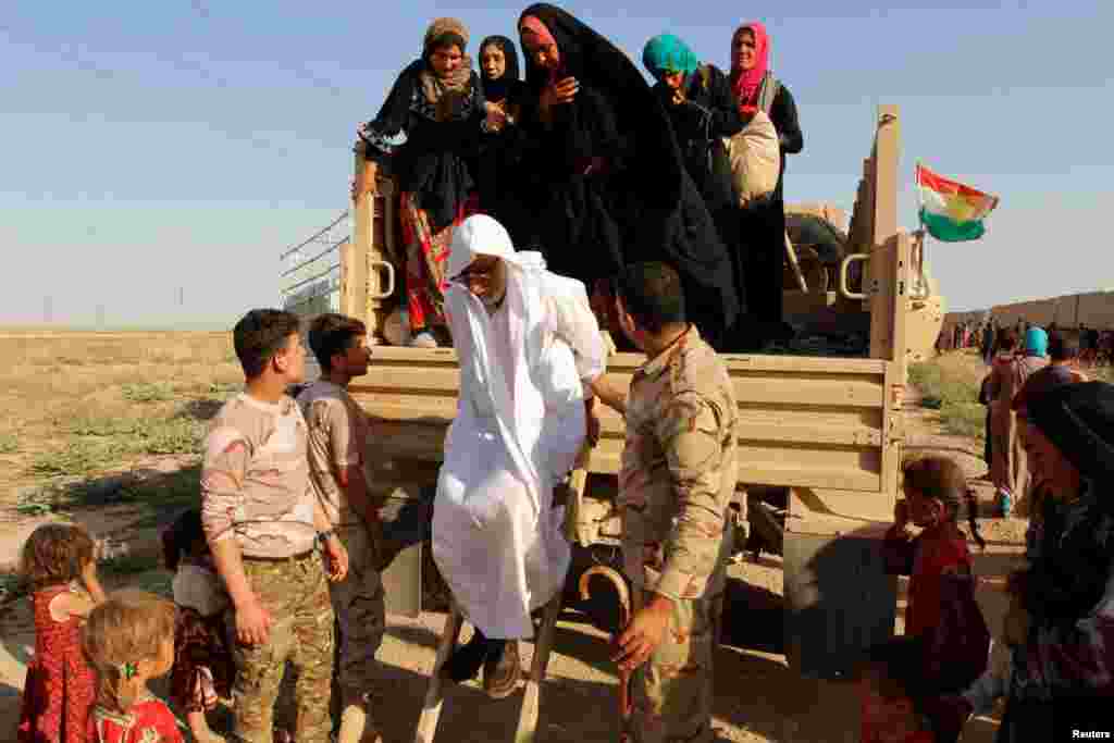 Pasukan Kurdi Peshmerga di Kirkuk, Irak, membantu warga Muslim Sunni yang baru tiba setelah melarikan diri dari kelompok ISIS di Hawija.