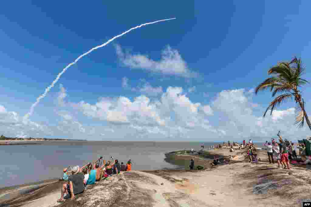 មនុស្ស​ម្នា​ថតរូប​រ៉ូកែត​អវកាស​ Ariane 5 ដែល​មាន​ផ្ទុក​ផ្កាយ​រណប​ Galileo ចំនួន​បួន​ពី​ស្ថានីយ​អវកាស​ ESA European Spaceport ក្នុង​ក្រុង Kourou កោះ​ French Guiana។​