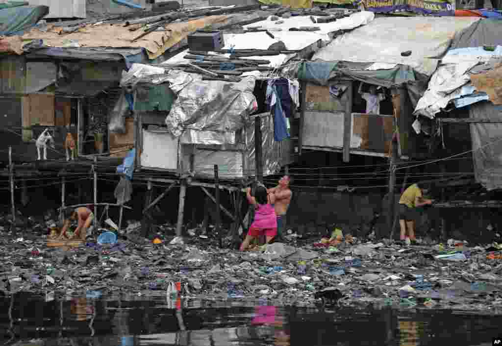 Warga di perkampungan kumuh di pinggiran Manila memperkuat rumah mereka menjelang datangnya Topan Rammasun di Filipina.