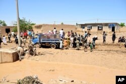 People receive food after heavy flooding in Baghlan province, Afghanistan, on May 12, 2024.