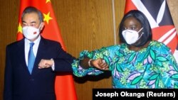 Menteri Luar Negeri China Wang Yi (kiri) dan dan Menteri Luar Negeri Kenya Raychelle Omamo bersalaman dengan mengadu siku dalam konferensi pers di Mobasa, Kenya, pada 6 Januari 2022. (Foto: Reuters/Joseph Okanga)