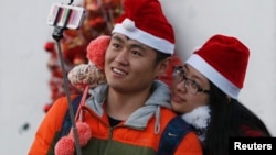 2014年12月24日，一对情侣带着圣诞帽在北京一所教堂里自拍。