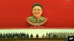 A Spanish Civil Guard officer (L) throws a sandwich to African migrants sitting at the top of a border fence during an attempt to cross into Spanish territory, between Morocco and Spain&#39;s north African enclave of Melilla.