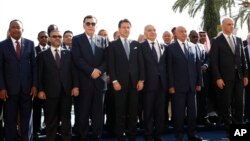 Italian Premier Giuseppe Conte, center, is flanked by Fayez Serraj, the PM of the U.N.-backed government in Tripoli, left, and UN special envoy for Libya, Ghassam Salame’, as they pose for a family photo in Palermo, Nov. 13, 2018. 