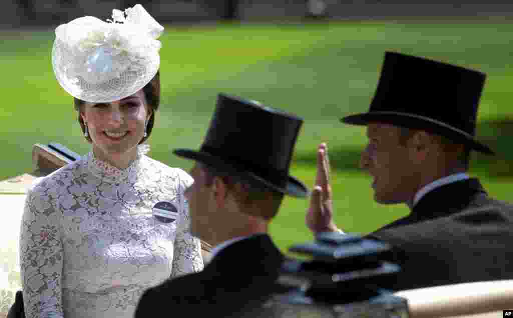 Britain's Kate, Duchess of Cambridge, left, smiles as she travels with Prince William, right and Prince Edward, in a open carriage to the parade ring on the first day of the Royal Ascot horse race meeting in Ascot, England.