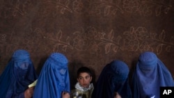 资料照片：2021年11月20日，在阿富汗喀布尔，世界粮食计划署组织的一个现金分发点，阿富汗妇女等待领取现金。一位高级官员于2023年7月28日星期五表示，由于“严重的资金危机”，联合国被迫削减对许多国家数百万人的粮食、现金支付和援助，由于严重饥饿达到创纪录的水平，联合国的捐款暴跌了约一半。