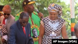 FILE: Zimbabwean President Robert Mugabe, left, is assisted by his wife Grace to get off the stage after addressing supporters at the party headquarters in Harare, Wednesday Feb, 10, 2016.