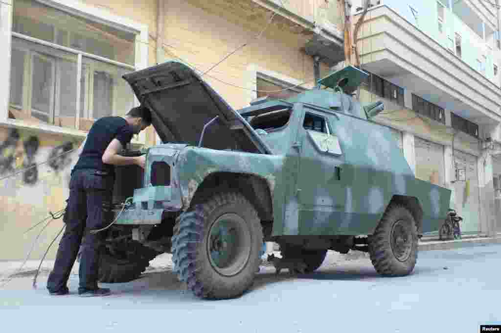 A man looks at the engine of a Syrian rebel vehicle in a street after fighting between Syrian rebel fighters and President Bashar al-Assad's forces in Hamidiyeh, Homs, Syria, July 1, 2012.