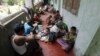 People eat food distributed at a Buddhist monastery used as a collective shelter for those displaced by recent violence in Sittwe, June 17, 2012.